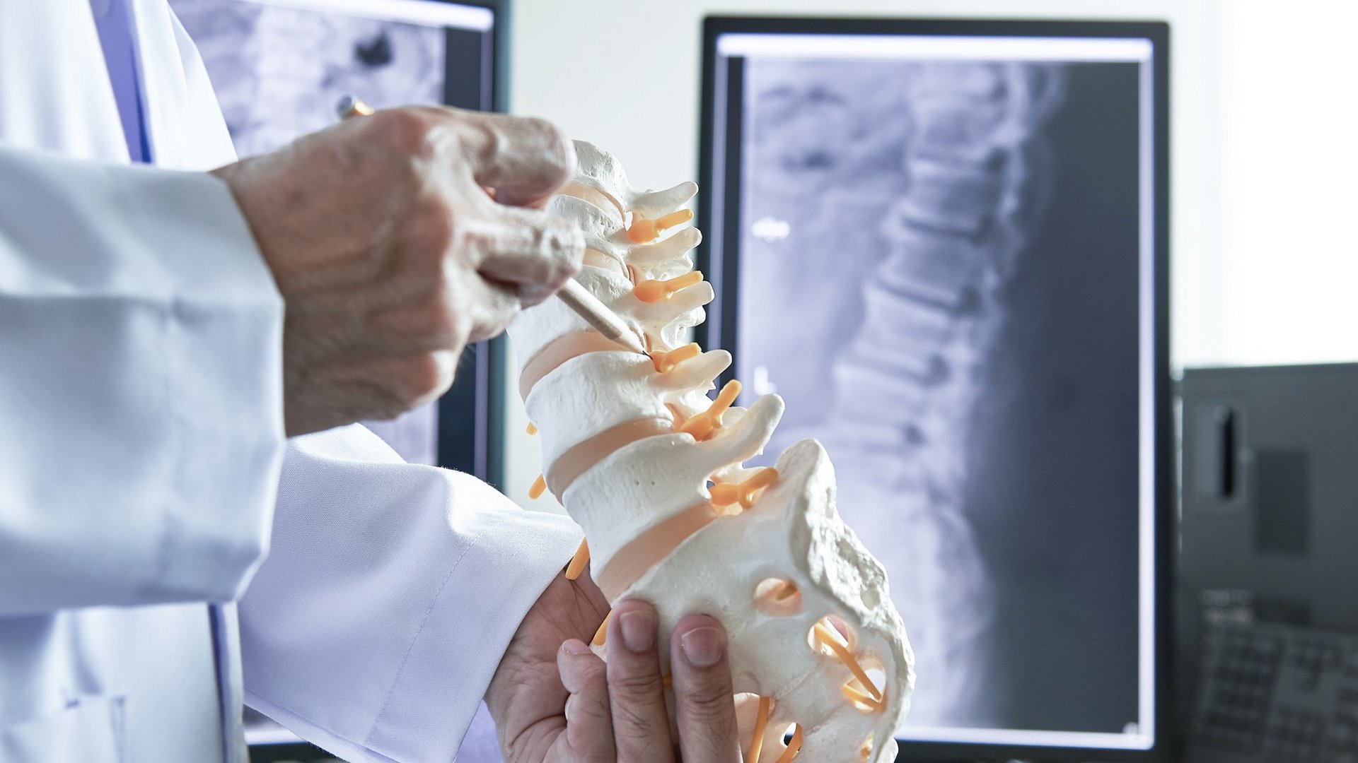 riwospine-vollendoskopische-wirbelsaeulenverfahren-planung.png Chirurg mit Wirbelsäulenmodell und Röntgenbildern – Planung vollendoskopischer Wirbelsäulenverfahren